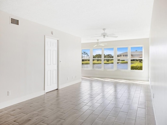 spare room featuring a water view, ceiling fan, and light hardwood / wood-style floors