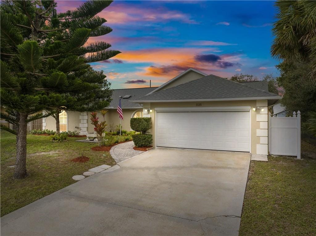 view of front of house featuring a garage and a yard