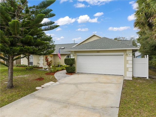 single story home featuring a front yard and a garage