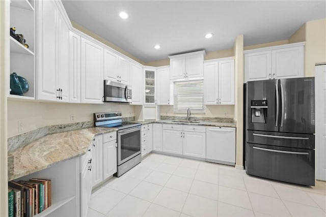 kitchen with light stone counters, white cabinetry, sink, and appliances with stainless steel finishes