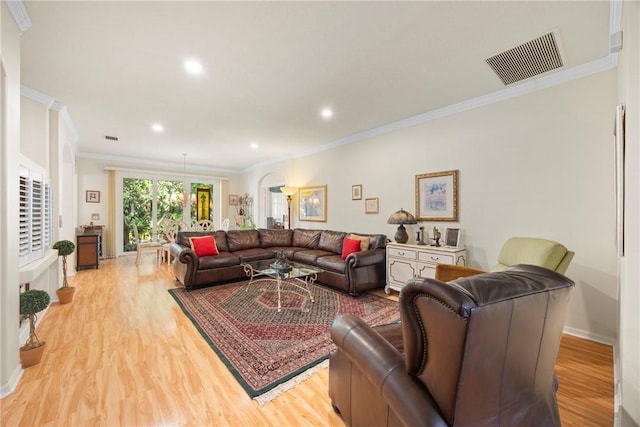 living room with light wood-type flooring and ornamental molding