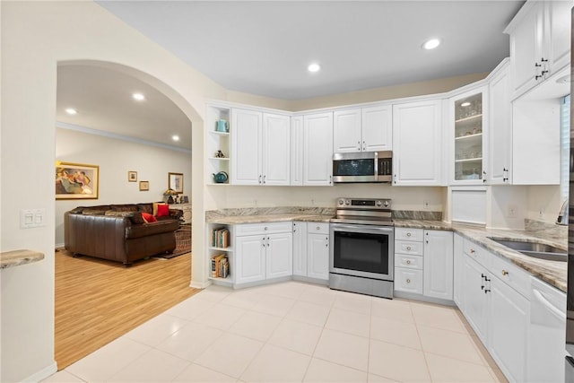 kitchen with white cabinetry, sink, light stone countertops, and appliances with stainless steel finishes