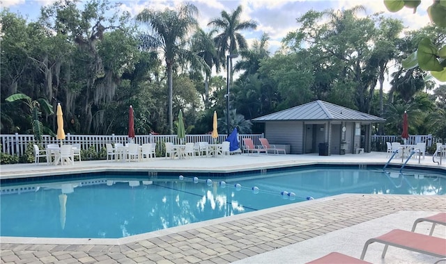 view of swimming pool with a patio area and an outbuilding