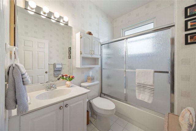 full bathroom with shower / bath combination with glass door, vanity, tile patterned flooring, and toilet