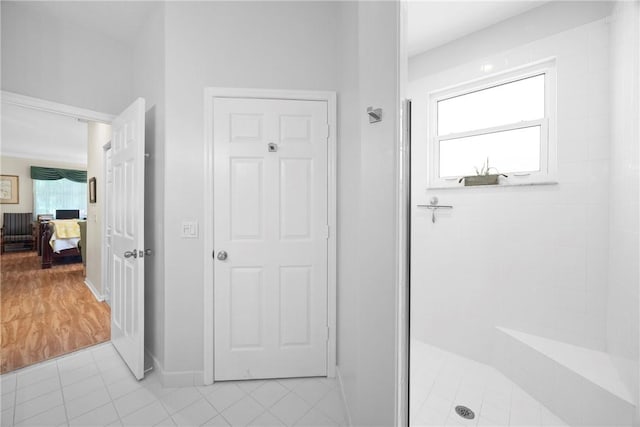 bathroom with a shower and tile patterned flooring