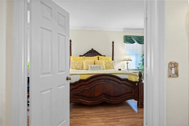 bedroom with crown molding and hardwood / wood-style flooring