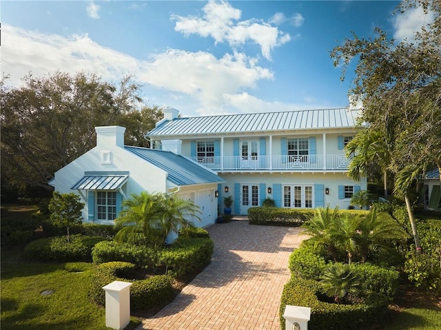 view of front of house featuring a balcony, metal roof, a garage, decorative driveway, and a standing seam roof