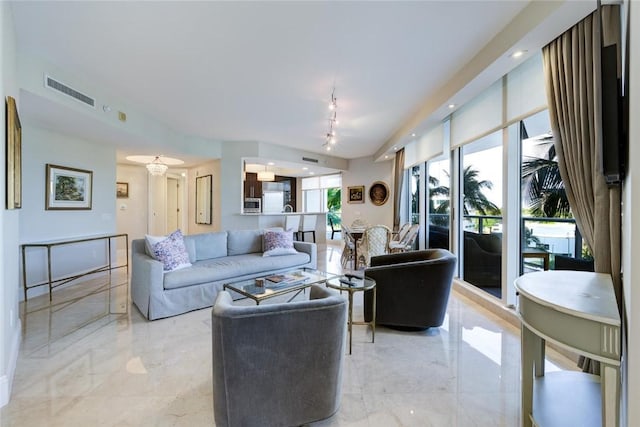 living room featuring light marble finish flooring and track lighting