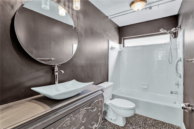 full bathroom featuring toilet, tiled shower / bath combo, vanity, and tile patterned flooring