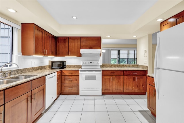 kitchen with sink, light stone counters, light tile patterned floors, backsplash, and white appliances