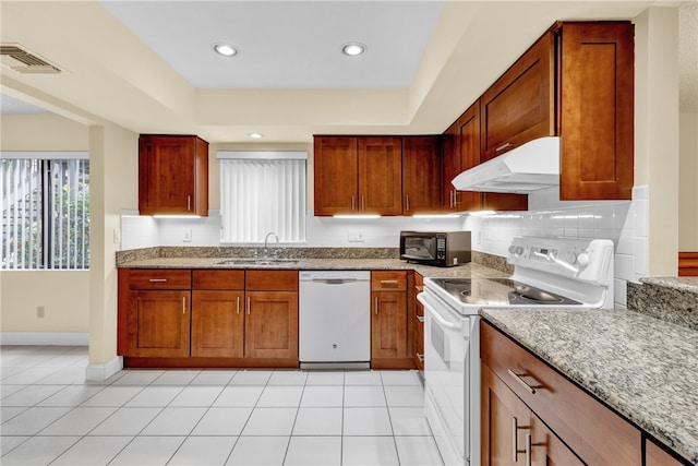 kitchen with light stone countertops, white appliances, sink, and light tile patterned flooring