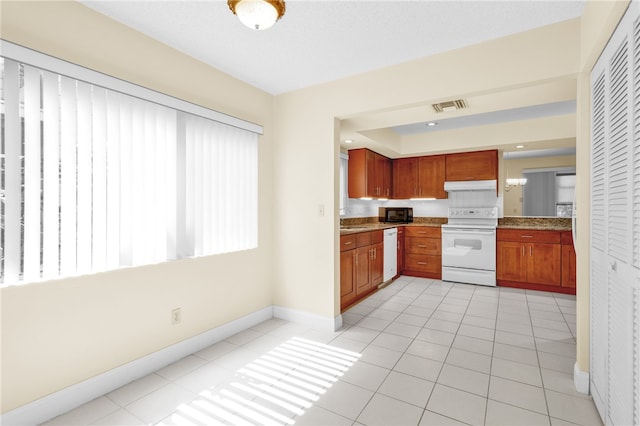 kitchen featuring light tile patterned floors and white appliances