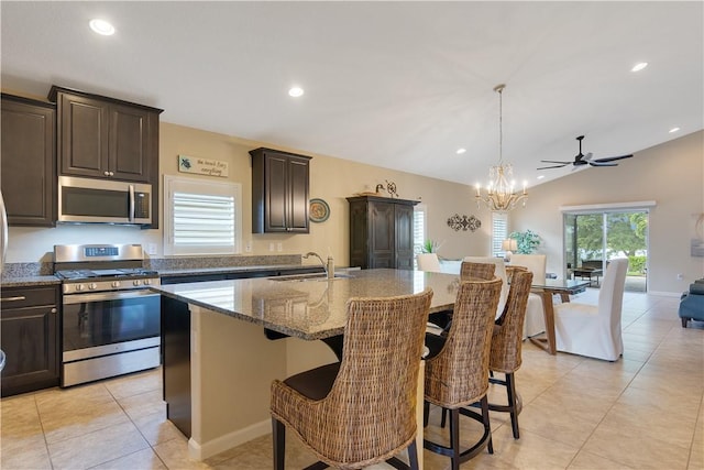 1712 Berkshire Cir SW, Vero Beach, FL 32968 - kitchen featuring stainless steel appliances, stone countertops, a kitchen breakfast bar, a kitchen island with sink, and dark brown cabinetry