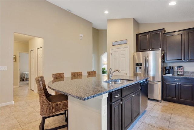 1712 Berkshire Cir SW, Vero Beach, FL 32968 - kitchen featuring dark stone countertops, stainless steel appliances, light tile patterned floors, a breakfast bar, and recessed lighting