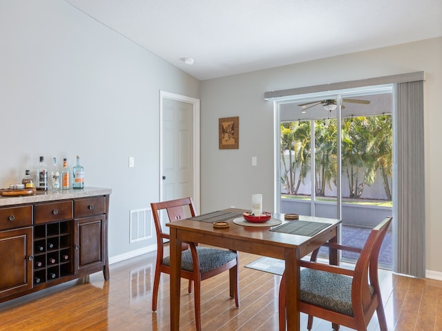 dining space featuring ceiling fan, vaulted ceiling, and light hardwood / wood-style floors