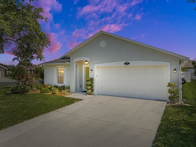 single story home with a garage and a lawn