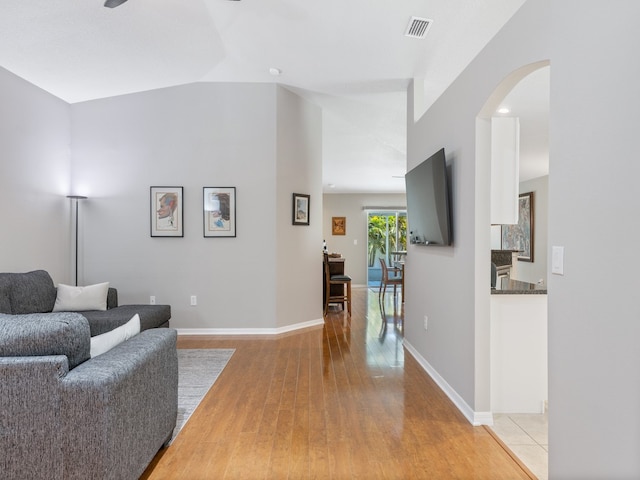 living room with light wood-type flooring and vaulted ceiling