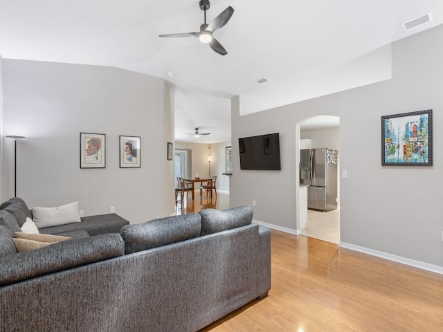 living room featuring vaulted ceiling, ceiling fan, and light hardwood / wood-style flooring