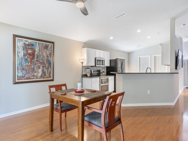 dining area featuring ceiling fan, light hardwood / wood-style flooring, and lofted ceiling