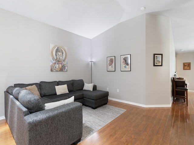 living room featuring lofted ceiling and hardwood / wood-style flooring