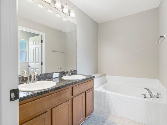 bathroom with tiled bath, vanity, and tile patterned floors