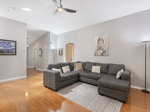 living room featuring ceiling fan, wood-type flooring, and lofted ceiling