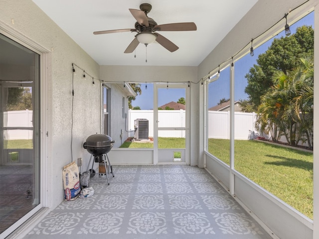 unfurnished sunroom with ceiling fan