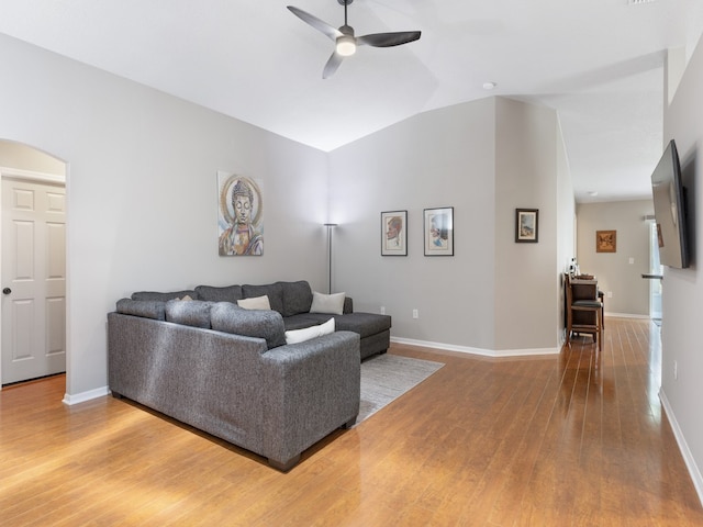 living room with hardwood / wood-style flooring, ceiling fan, and vaulted ceiling