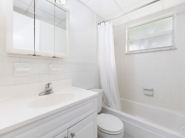 923 22nd Pl Unit 209, Vero Beach, FL 32960 - full bathroom with toilet, vanity, shower / tub combo with curtain, and tile walls