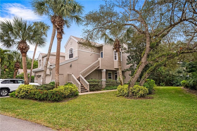 view of property exterior featuring a lawn, stairs, and stucco siding