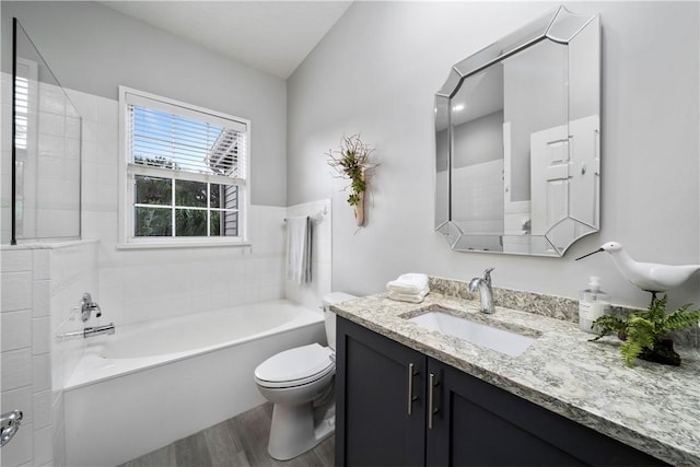 full bathroom featuring vanity, toilet, a bath, and wood finished floors