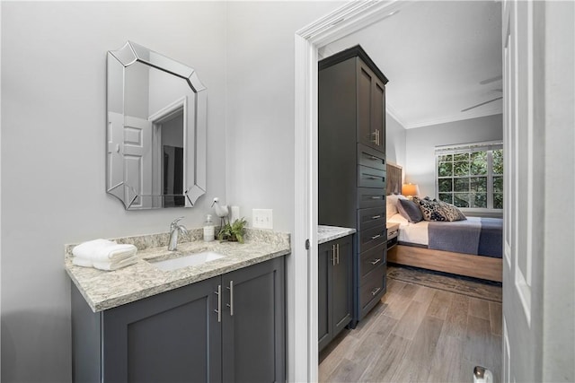 bathroom with crown molding, ensuite bath, wood finished floors, and vanity