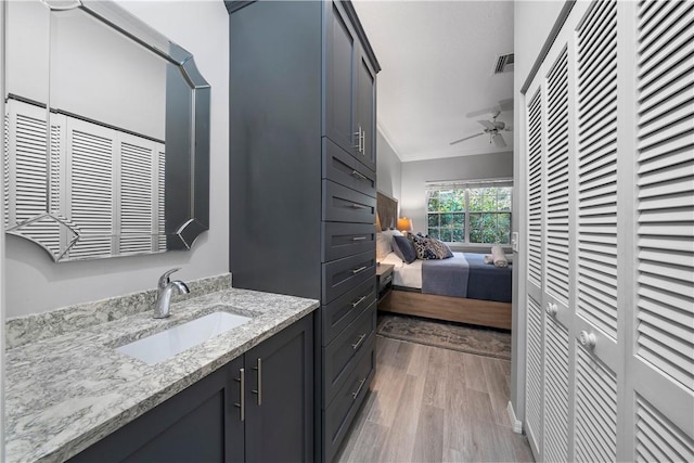 1440 Winding Oaks Cir W Unit A204, Vero Beach, FL 32963 - bathroom featuring a ceiling fan, vanity, crown molding, wood finished floors, and ensuite bath