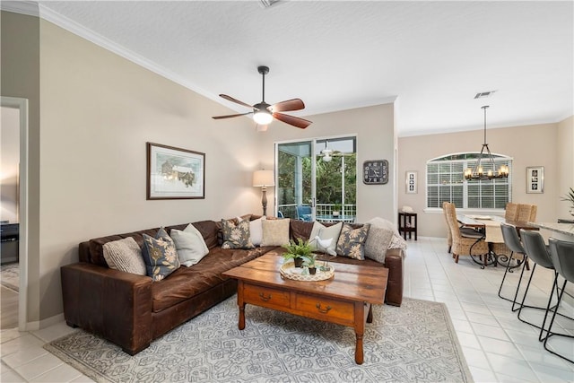 living area with light tile patterned floors, visible vents, ceiling fan with notable chandelier, and ornamental molding