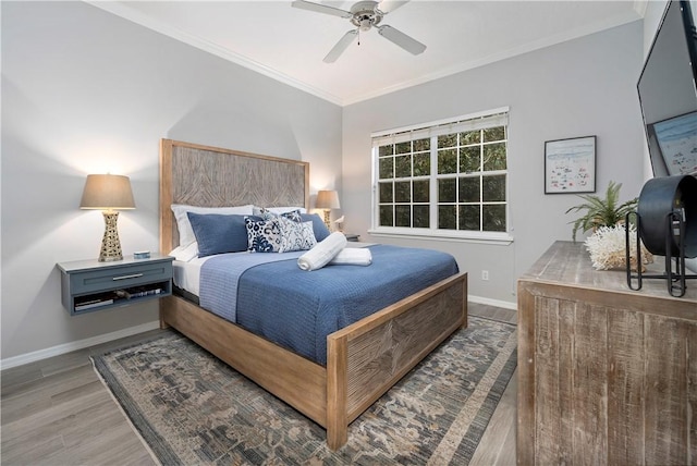 bedroom featuring baseboards, light wood-style flooring, crown molding, and a ceiling fan