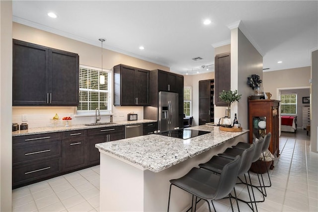 1440 Winding Oaks Cir W Unit A204, Vero Beach, FL 32963 - kitchen with appliances with stainless steel finishes, crown molding, light tile patterned floors, a sink, and a kitchen breakfast bar