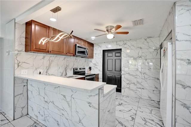 kitchen featuring hanging light fixtures, stainless steel appliances, kitchen peninsula, and ceiling fan