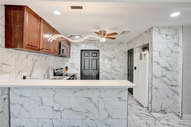 kitchen with ceiling fan, stainless steel appliances, a kitchen breakfast bar, decorative light fixtures, and kitchen peninsula