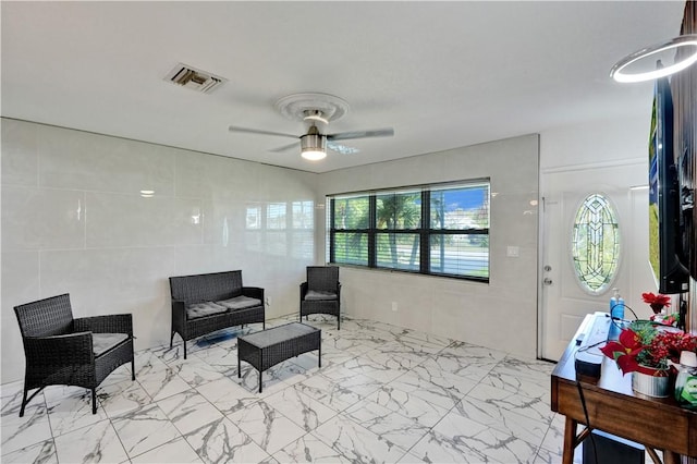 interior space with tile walls and ceiling fan