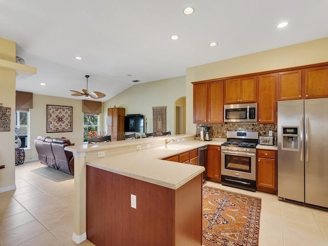 kitchen with light tile patterned flooring, sink, backsplash, kitchen peninsula, and stainless steel appliances