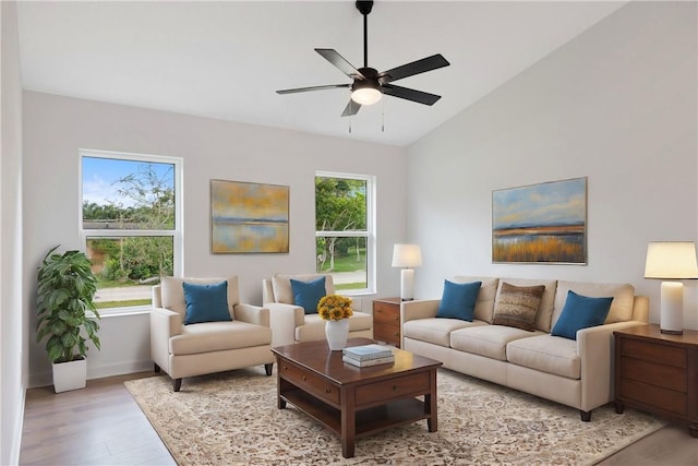 living room with ceiling fan, a healthy amount of sunlight, lofted ceiling, and light wood-type flooring