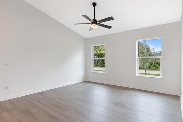 empty room featuring hardwood / wood-style flooring, ceiling fan, and lofted ceiling