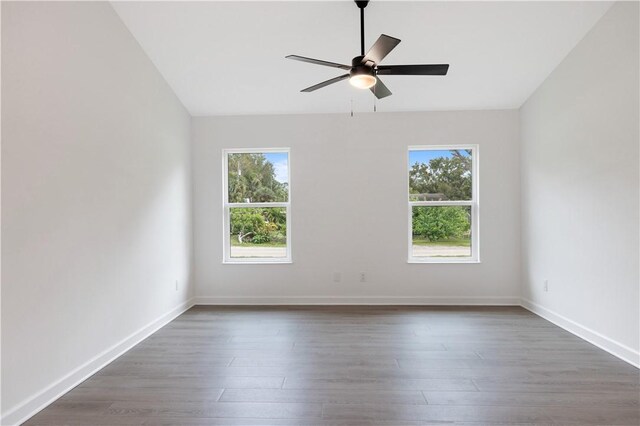 spare room featuring ceiling fan, dark hardwood / wood-style flooring, lofted ceiling, and a wealth of natural light