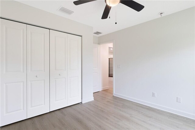 unfurnished bedroom featuring ceiling fan, light hardwood / wood-style flooring, and a closet