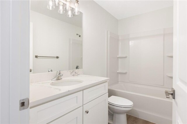 full bathroom featuring shower / washtub combination, hardwood / wood-style floors, vanity, and toilet