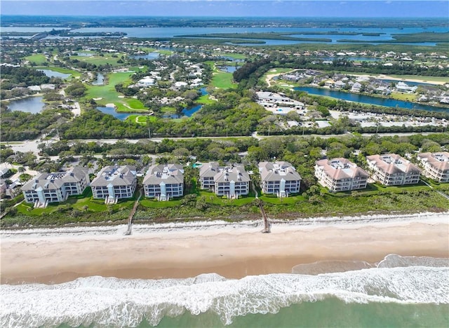 drone / aerial view featuring a beach view and a water view