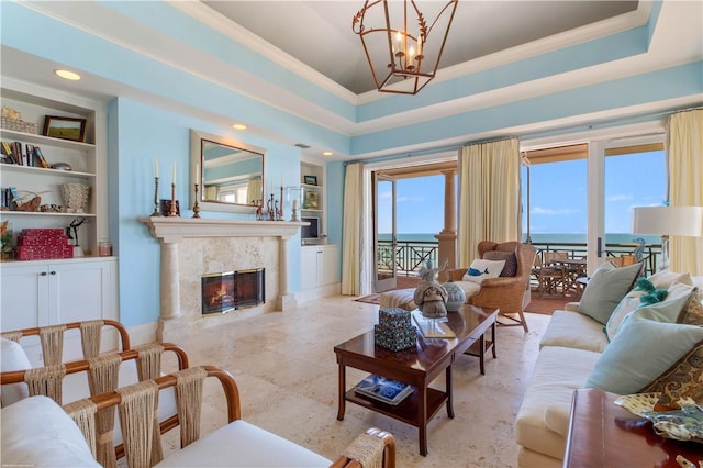 living room with crown molding, built in shelves, and a notable chandelier