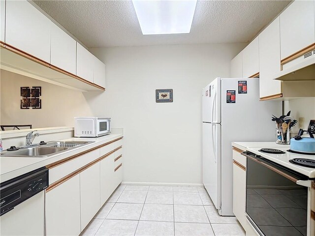 32 Plantation Dr Unit 102, Vero Beach, FL 32966 - kitchen with white appliances, a sink, light countertops, a textured ceiling, and white cabinetry