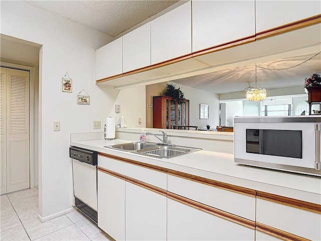 kitchen with white cabinetry, sink, light tile patterned floors, white appliances, and a chandelier