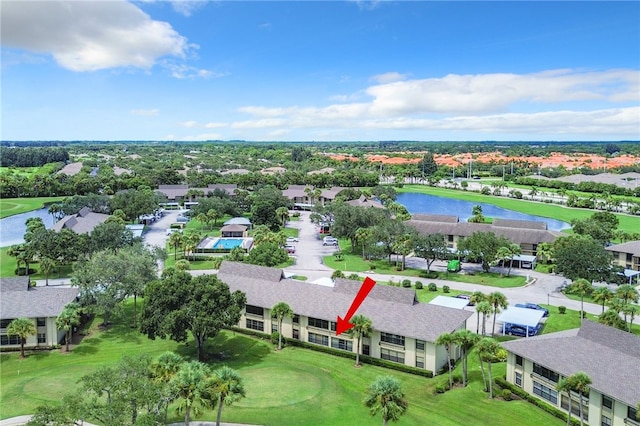 drone / aerial view featuring a residential view, view of golf course, and a water view